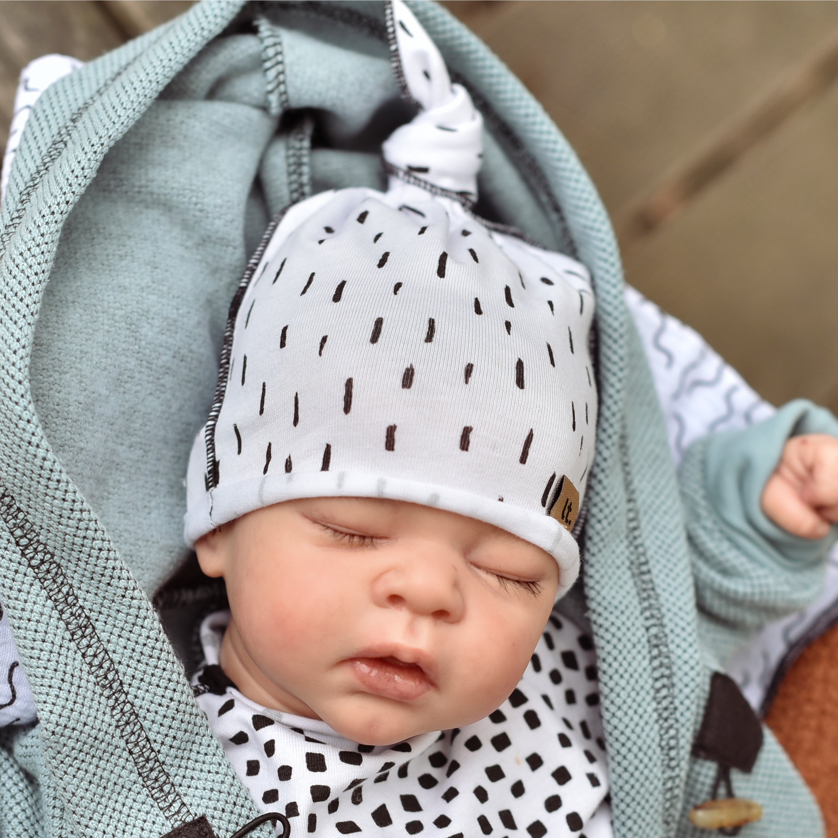 bílá kojenecká čepička s potiskem